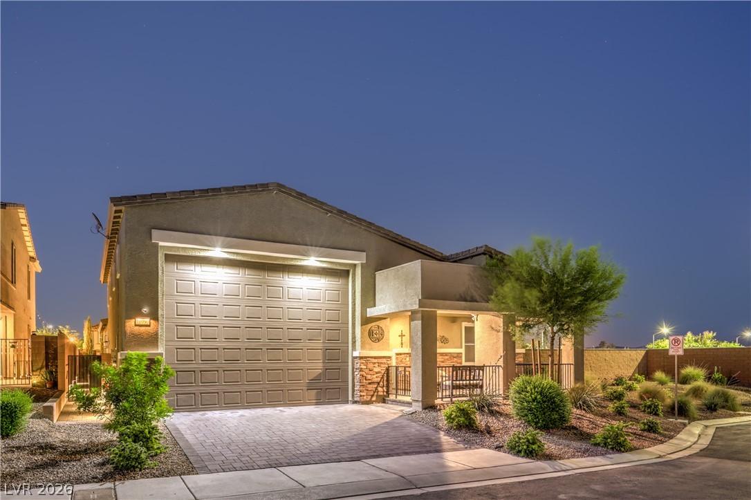 Image 2: Front facade warmly illuminated, features a paver