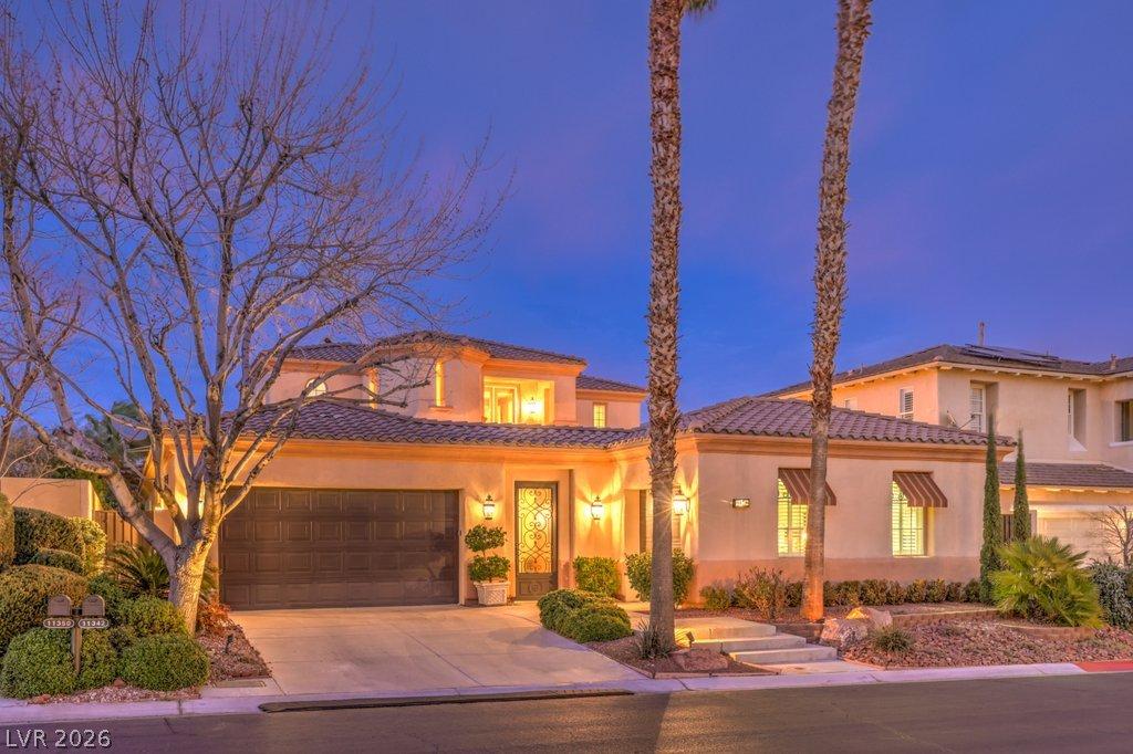 Image 2: Illuminated at dusk, this home boasts an elegant t