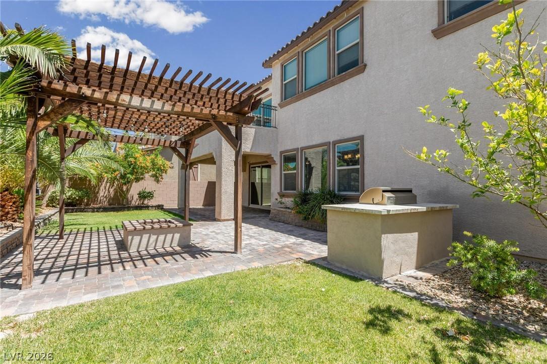 Image 3: A spacious backyard features a pergola-covered pat