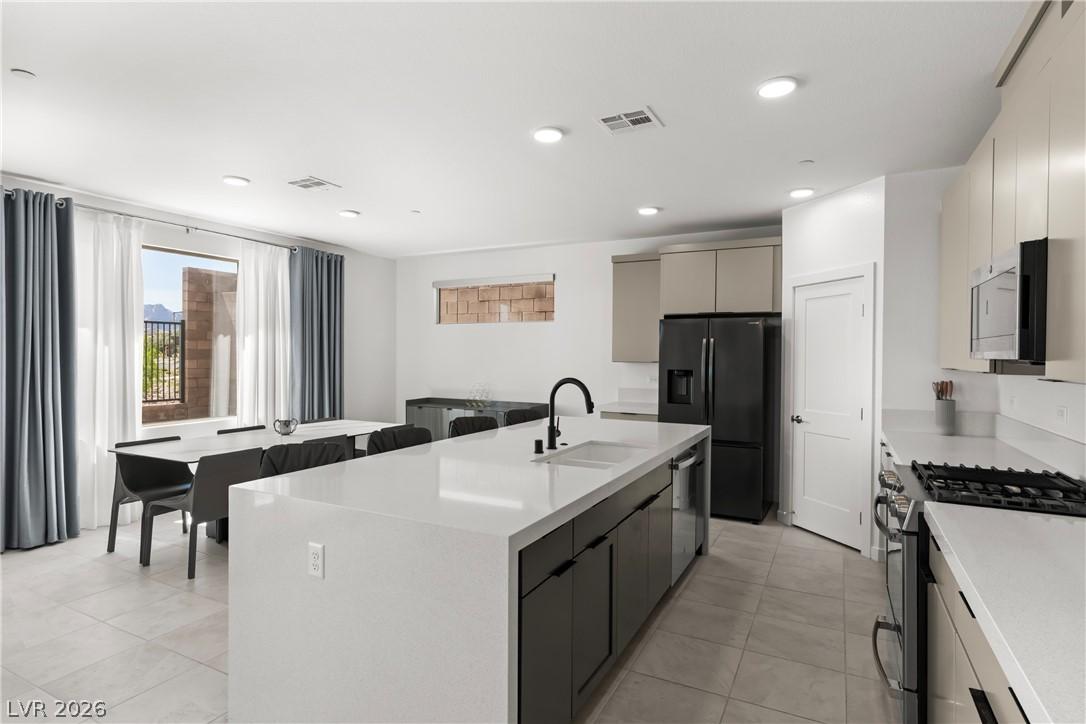 Image 3: Bright, modern kitchen with an expansive island an