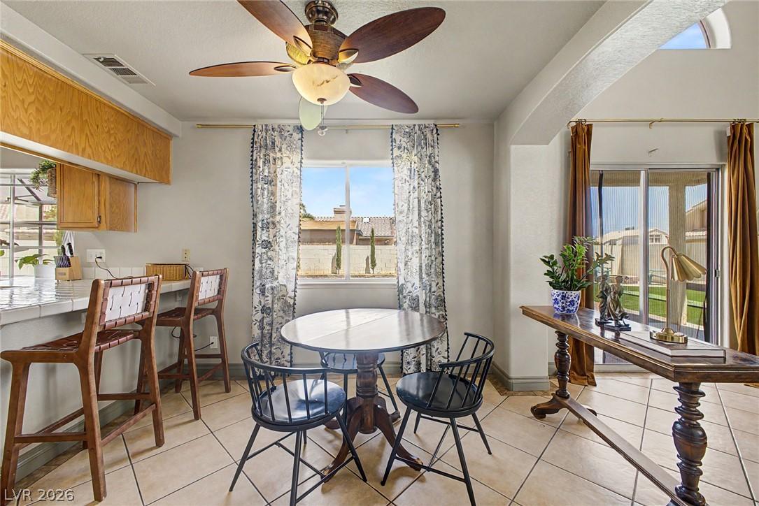 Image 4: A well-lit kitchen area features a breakfast bar,