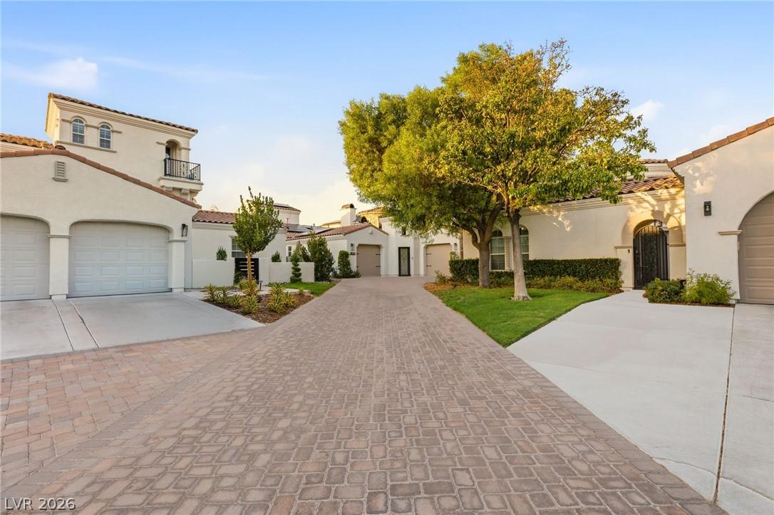 Image 2: A graceful paver driveway leads to multiple garage
