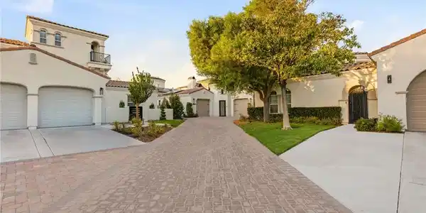 Image 2: A graceful paver driveway leads to multiple garage