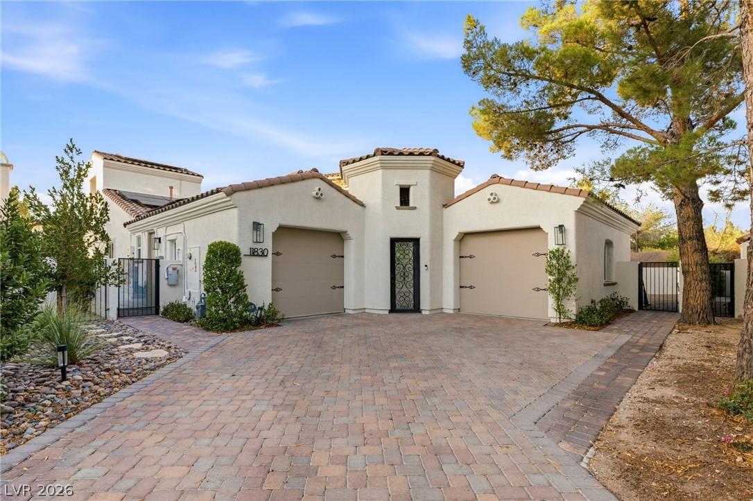 Image 3: A striking stucco facade with an inviting paver dr