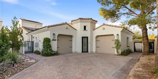 Image 3: A striking stucco facade with an inviting paver dr