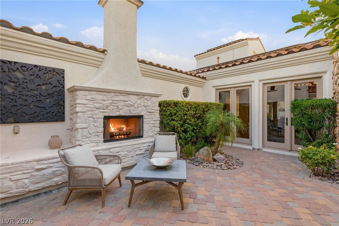 Image 4: An inviting outdoor patio features a stone firepla