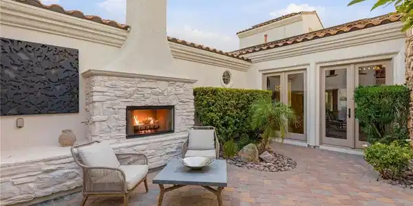 Image 4: An inviting outdoor patio features a stone firepla
