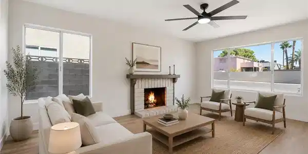 Image 4: A comforting fireplace anchors this bright living