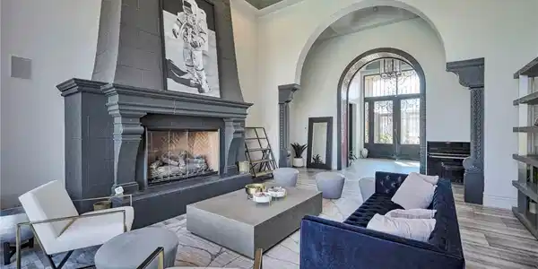 Image 2: An opulent fireplace anchors this spacious living