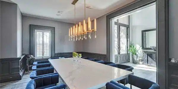 Image 4: A striking linear chandelier illuminates a grand d