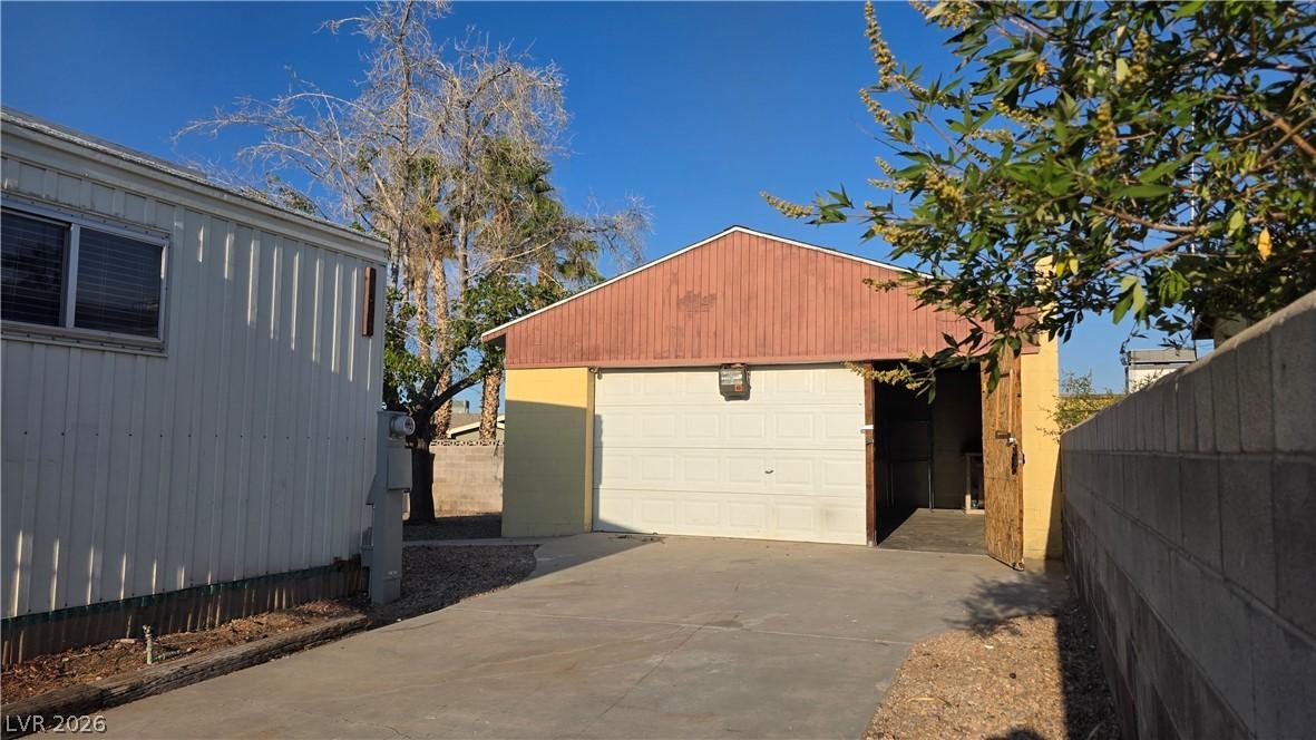 Image 2: A detached garage with a convenient concrete drive