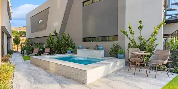 Image 2: A sleek pool with a waterfall feature highlights t