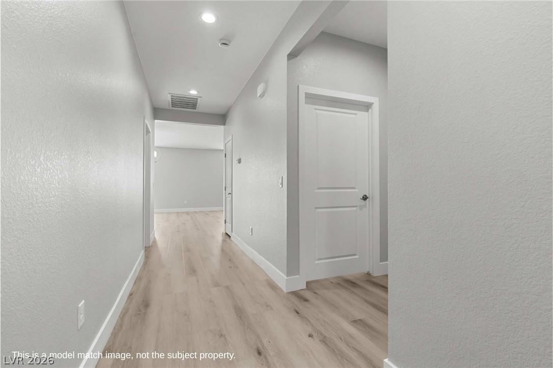 Image 2: Hallway featuring a textured wall, light wood-type