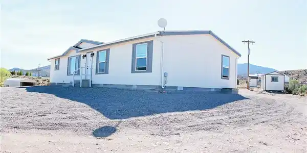 Image 2: A well-maintained manufactured home sits elevated