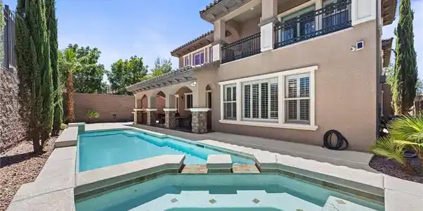 Image 2: A charming backyard retreat offers a stamped concr