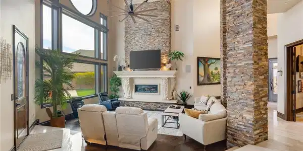 Image 3: Living room with a towering ceiling, ceiling fan,