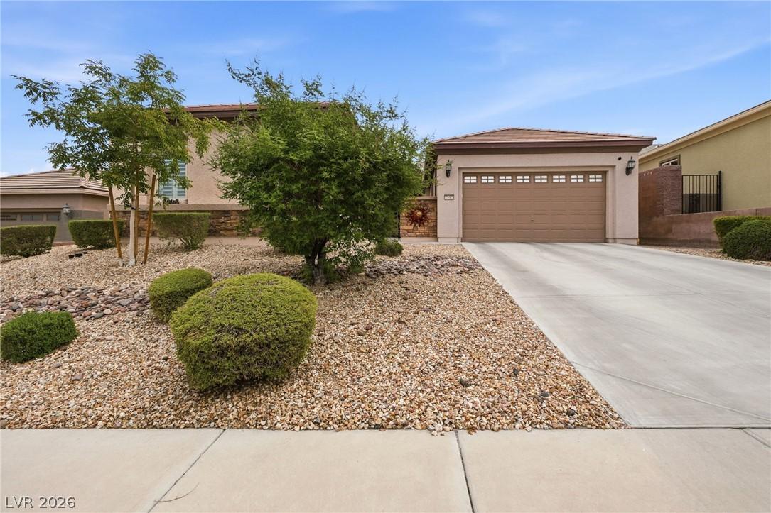 Image 2: A well-maintained concrete driveway leads to a fro