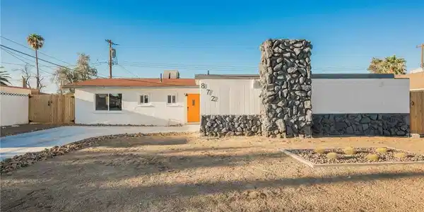 Image 3: Bold stone masonry accents the facade of this mid-