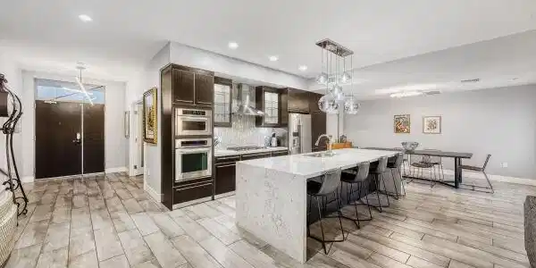 Image 3: An open-concept kitchen features stone countertops