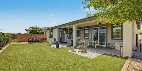 Image 3: A spacious backyard awaits, featuring a covered pa