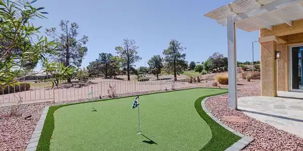 Image 2: An inviting backyard putting green borders a stone