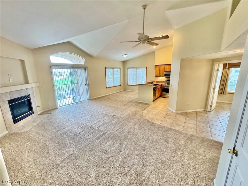 Image 3: A spacious living area with vaulted ceilings, a co