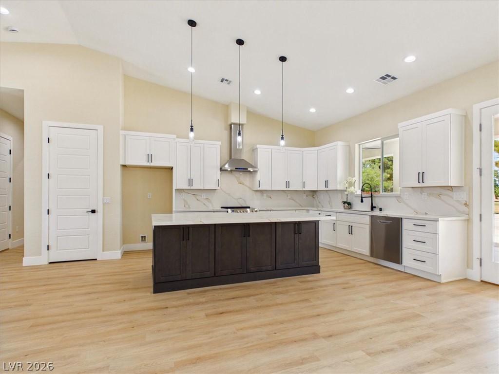 Image 3: A pristine kitchen features a large island, stainl