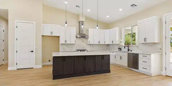 Image 3: A pristine kitchen features a large island, stainl