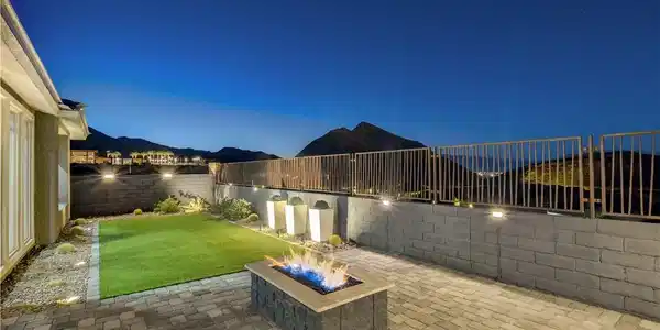 Image 2: An inviting backyard oasis offers a fire pit, pati