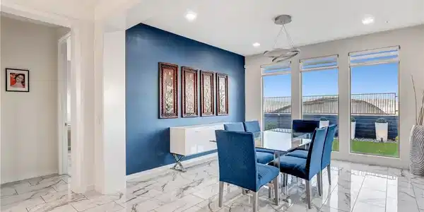 Image 4: A well-lit dining area features a deep blue accent
