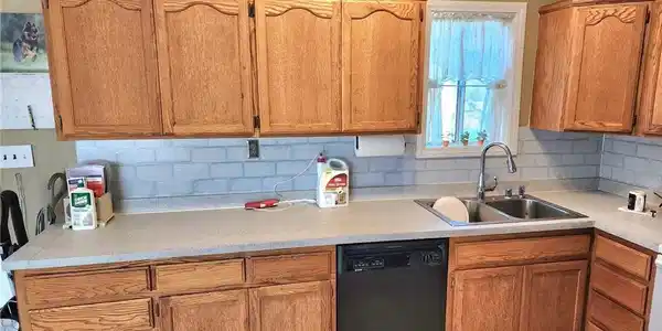 Image 3: Kitchen featuring black dishwasher, light countert