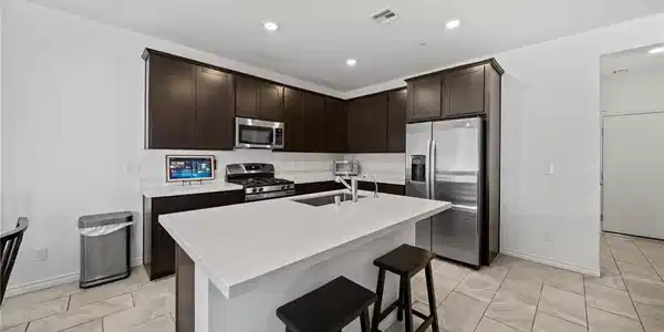 Image 4: Modern kitchen with white quartz countertops and a
