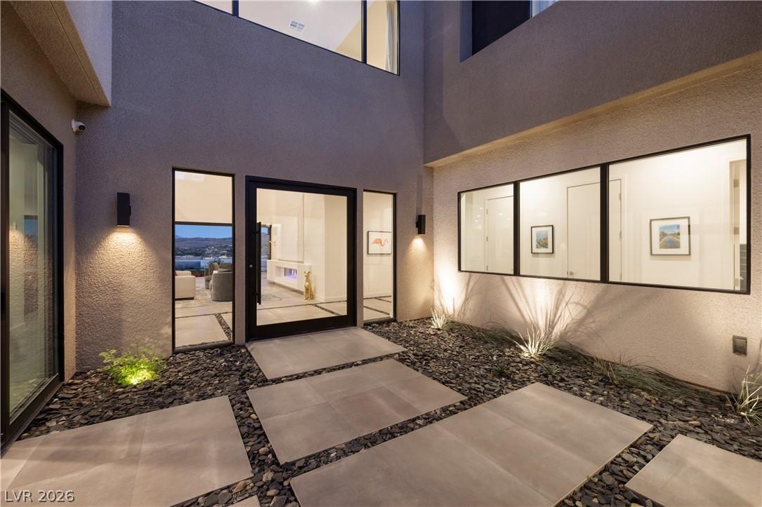 Image 4: A modern entry with geometric pavers and ambient l