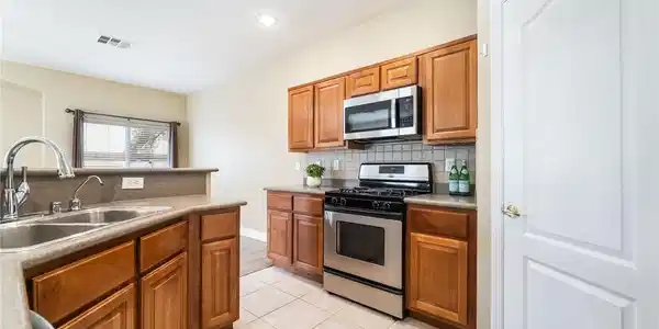Image 4: Warm wood cabinetry pairs with durable tile floori