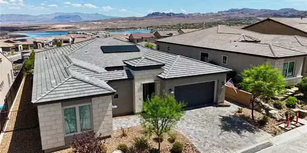 Image 2: A modern tile-roof home overlooks a serene body of