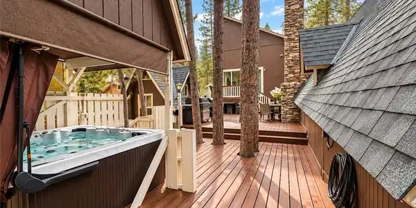 Image 4: A spacious composite deck features a built-in spa