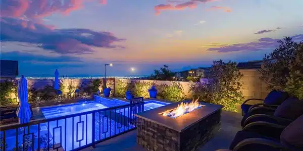 Image 2: An inviting fire pit complements the shimmering po