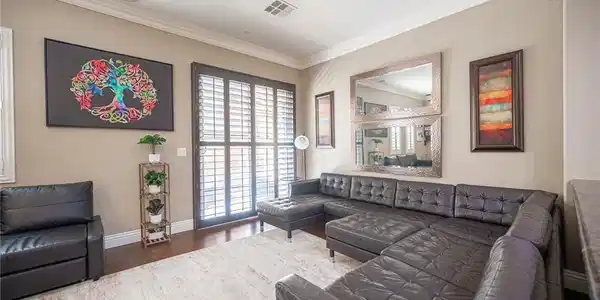 Image 4: Living area with dark wood finished floors and orn