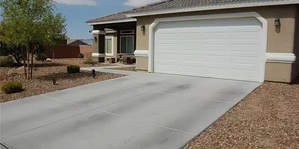Image 2: A well-maintained stucco home with a concrete driv