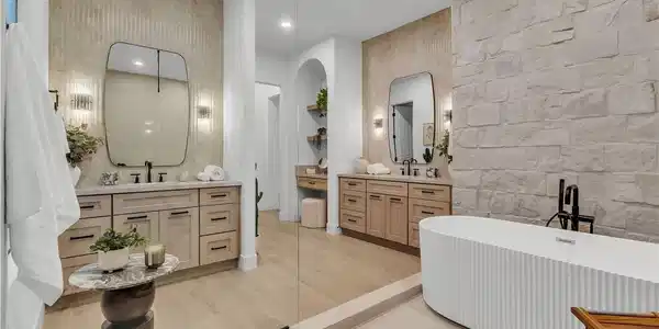 Image 2: Natural stone accents and dual wood vanities creat