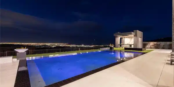 Image 2: An illuminated infinity pool overlooks sparkling c