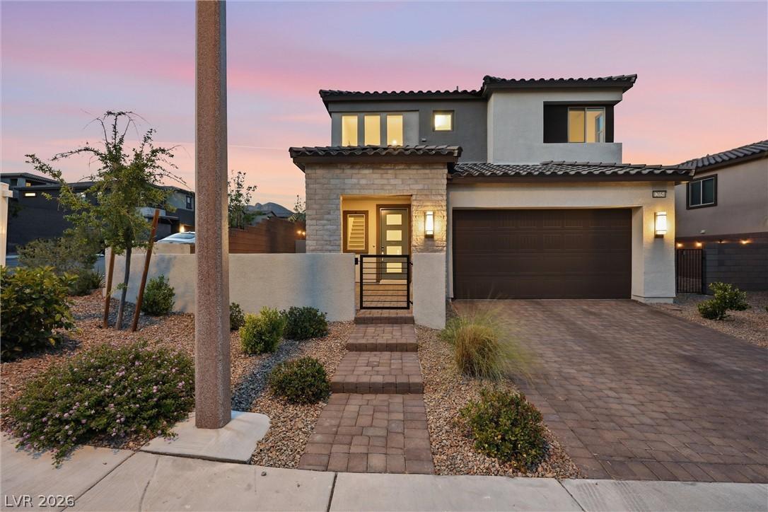 Image 2: A modern facade with a paver driveway and a charmi
