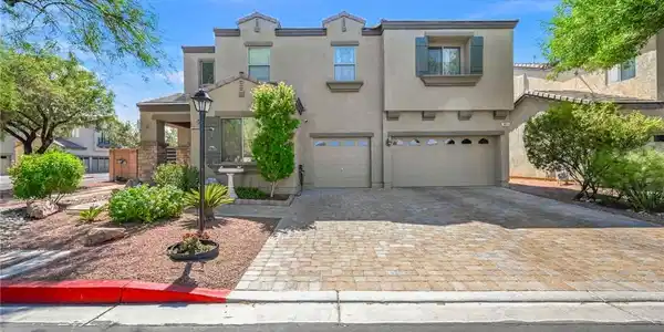 Image 3: A spacious driveway lined with pavers leads to the