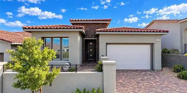 Image 3: A paved driveway leads to this modern home featuri