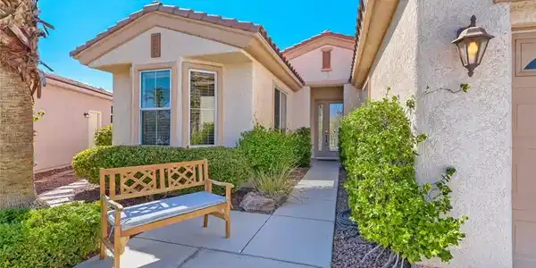 Image 2: Sunlight bathes a welcoming stucco facade featurin