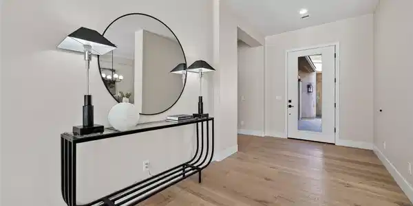 Image 4: Smooth wood floors and a glass-inset entry door cr
