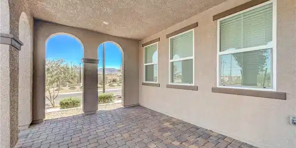 Image 4: A covered patio with brick pavers and arched openi