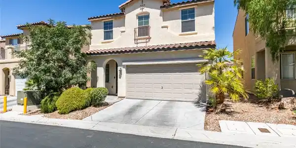 Image 2: A charming stucco home with a terracotta tile roof