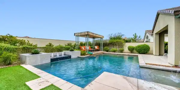 Image 4: An inviting backyard oasis features a swimming poo
