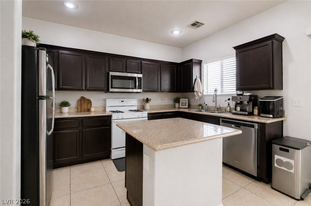 Image 3: Granite counters and dark wood cabinetry provide a